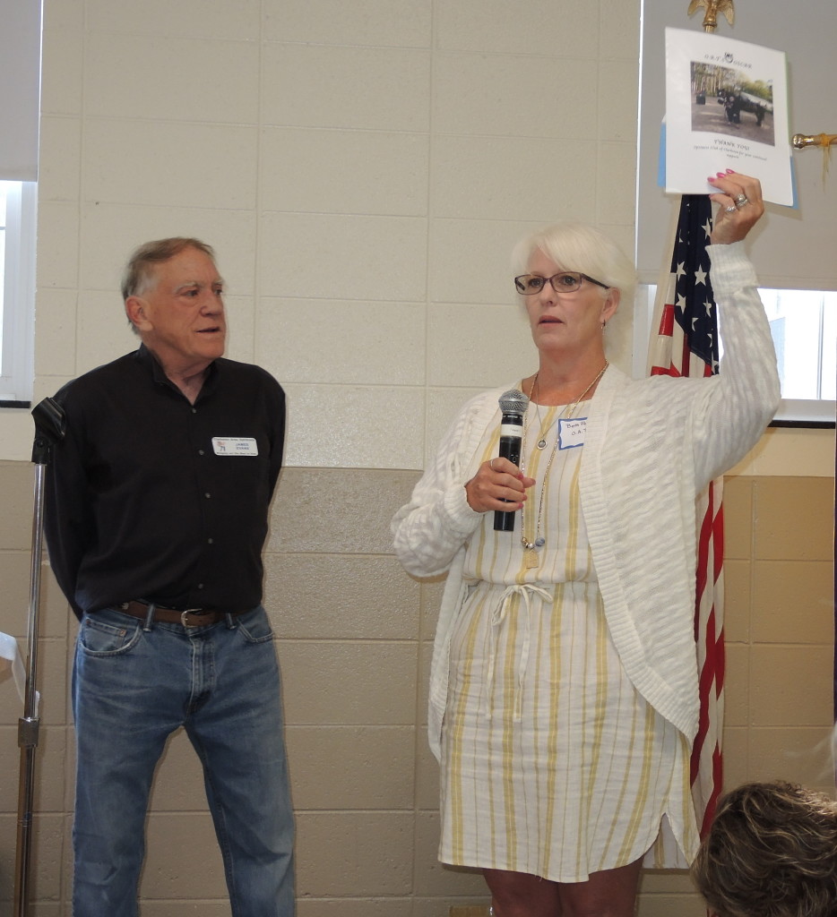 Beth Pellerito, executive director for O.A.T.S., with Jim Evans of Clarkston Optimists, explains how the grant for the horse-based therapy center for kids will be used. Photo by Phil Custodio