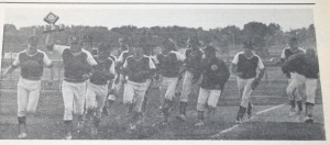The 1976 Clarkston varsity baseball squad make a triumphant run around the field after receieving its state championship trophy, as shown in the Clarkston News. The Wolves beat Owosso 3-0 in the semi-final match and went on to win the championship with a 2-1 victory over Hazel Park. Clarkston News Archives. 
