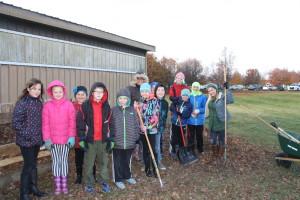 Dr. Kristen Gretka and her fifth grade Global Thinking class, with Clarkston Family Farm CEO Chelsea O'Brien, work on the hoop house outside Independence Elementary. Photo by Jessica Steeley