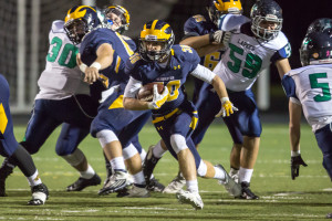 Michael Fluegel runs past Lapeer’s block while the offensive line keeps Lightning back. Photo by Larry Wright