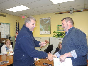 Newly elected Mayor Steve Percival, at right,  receives the gavel from outgoing Mayor Joe Luginski. Photo by Phil Custodio