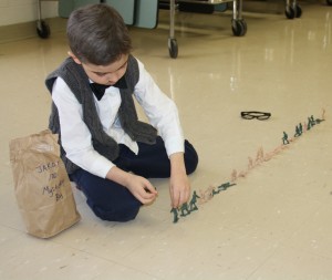 First grader Jakob Dula counts out a line of toy army figures.