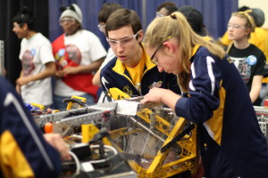 Jason Richards and Jessica Ray check the robot before putting it on the field for their morning  match on Friday. Photo by Wendi Reardon Price