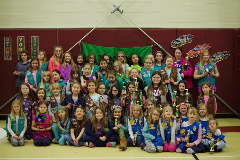 The Girl Scouts smile for a photo after completing the Pinewood Derby race. Photo submitted