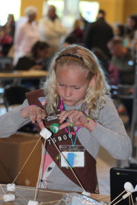 Lainey Brown creates a catapult out of sticks and marshmallows at Camp Invention's booth. Photo by Wendi Reardon Price