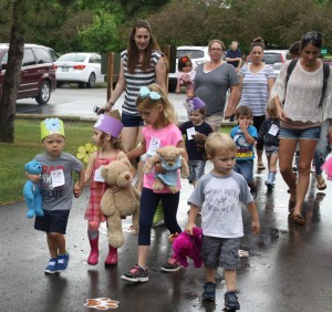 Kids walk with their stuffed animal friends in the parade. 