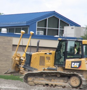 A construction worker drives a bulldozer in front of Bailey Lake Elementary. Photo by Jessica Steeley 