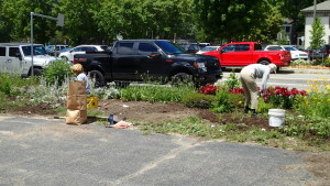Volunteers weed and plant flowers in the garden next to the Clarkston News building. Photo provided
