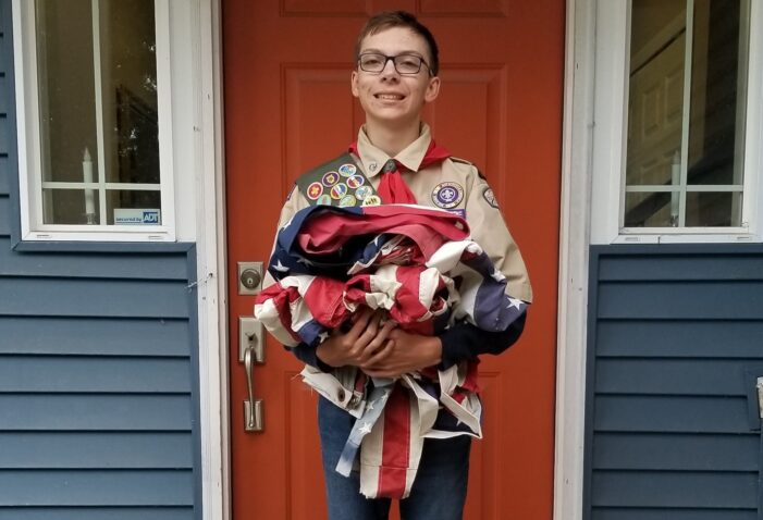 Local scout retiring flags for project